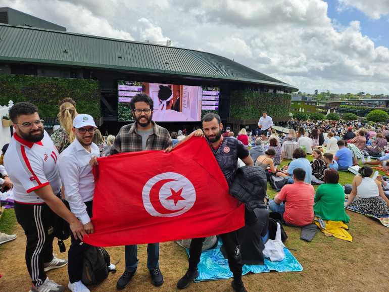 Hamza, Sami, Wasim and Adam - a group of Tunisian friends living in the UK - have gathered on the Hill with a big Tunisian flag to watch their hero try and make history. While their flag had to be folded away due to tournament rules, their spirits remain high.[Hafsa Adil/Al Jazeera]