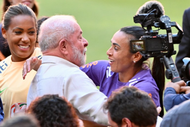 Brazilian President Luiz Inacio Lula da Silva hugs player Marta