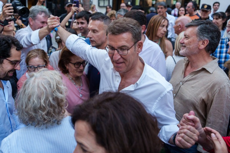 Spanish right-wing opposition party Partido Popular (PP) leader Alberto Nunez Feijoo greets supporters after an electoral meeting as part of Spain's general election campaign