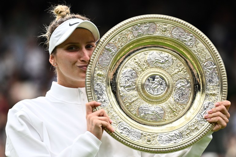 Czech Republic's Marketa Vondrousova celebrates as she kisses the Venus Rosewater Dish trophy during the prize ceremony after winning the women's singles final tennis match against Tunisia's Ons Jabeur on the thirteenth day of the 2023 Wimbledon Championships at The All England Lawn Tennis Club in Wimbledon, southwest London, on July 15, 2023. (Photo by SEBASTIEN BOZON / AFP) / RESTRICTED TO EDITORIAL USE
