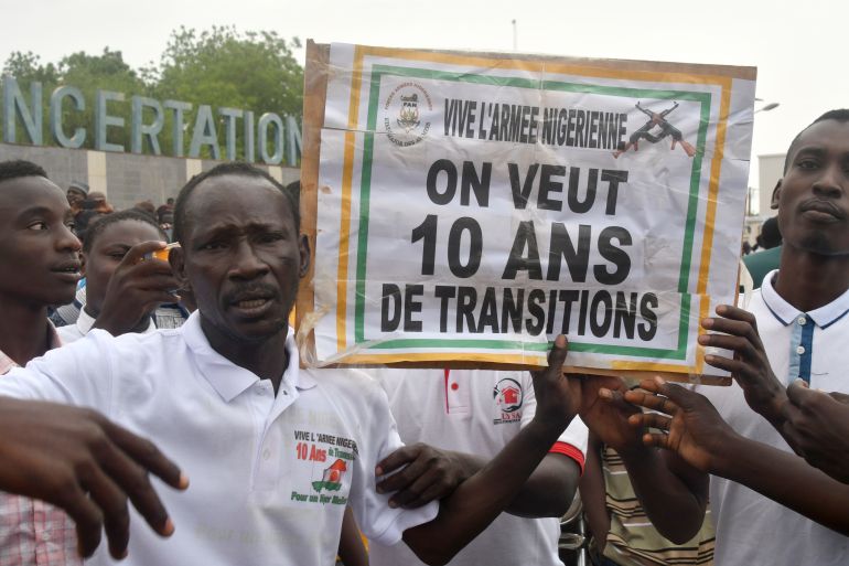 Supporters of the Nigerien defence and security forces hold a placard during a demonstration outside the national assembly in Niamey on July 27, 2023