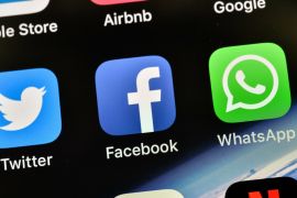 FILE - In this Thursday, Nov. 15, 2018 file photo the icons of Facebook and WhatsApp are pictured on an iPhone in Gelsenkirchen, Germany. German antitrust authorities have issued a ruling prohibiting Facebook from combining user data from different sources. (AP Photo/Martin Meissner)