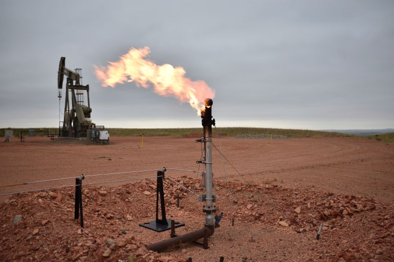 A flare for burning excess methane, or natural gas, from crude oil production is seen at a well pad in Watford City, N.D., Aug. 26, 2021. (AP Photo/Matthew Brown)
