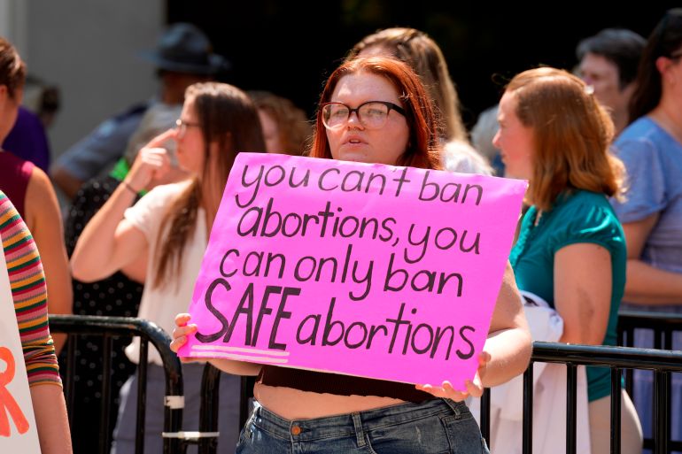 A woman holds a sign that says: 'You can't ban abortions, you cab only ban SAFE abortions'.