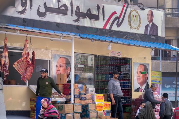 Clients buy groceries at a government sponsored shop fronted with Egyptian President Abdel Fattah el-Sissi posters in Cairo, Egypt, Feb 27, 2023