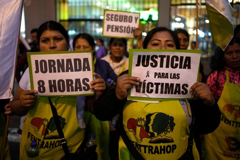People dressed in yellow shirts hold up signs that read, "Jornada 8 horas" and "Justicia por las victimas"