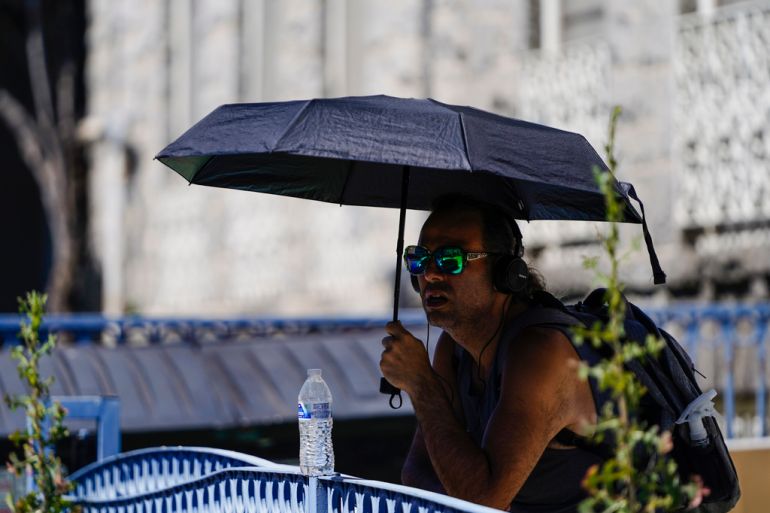 Man in sunglasses holding an umbrella