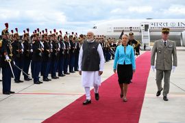 India's Prime Minister Narendra Modi, France's Prime Minister Elisabeth Borne and Deputy General to the Military Governor of Paris Eric Chasboeuf walk past French Republican Guards at the Orly airport in Orly, Paris' suburb, Thursday, July 13, 2023. Indian Prime Minister Narendra Modi begins a two-day visit to France and will attend the traditional Bastille Day military parade. (Bertrand Guay, Pool via AP)