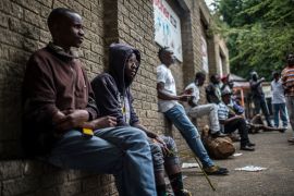 Zimbabwean and Mozambican migrants wait outside a hardware store on the corner of Derby and Queen streets in the hope to get odd jobs on November 23, 2017 in Johannesburg