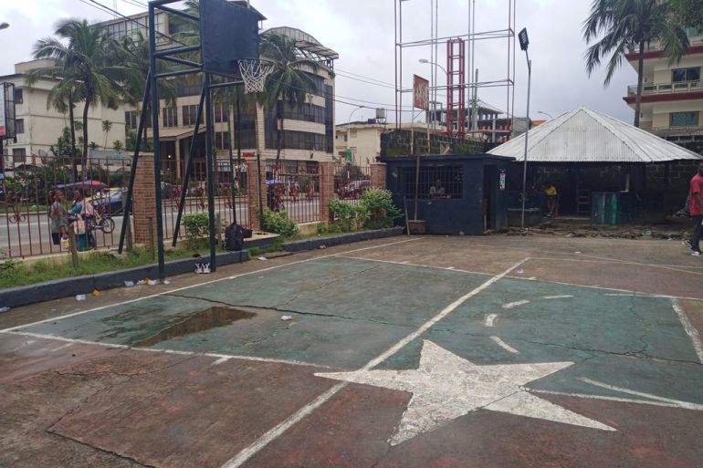 Two white stars painted on a basketball court in the compound of St Peter's Church in Monrovia, Liberia indicate where victims of the first Liberian war have been buried [Courtesy of Robtel Pailey]