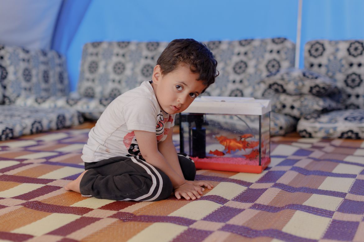 Abdulraheem, 3, sits in the tent where he currently lives