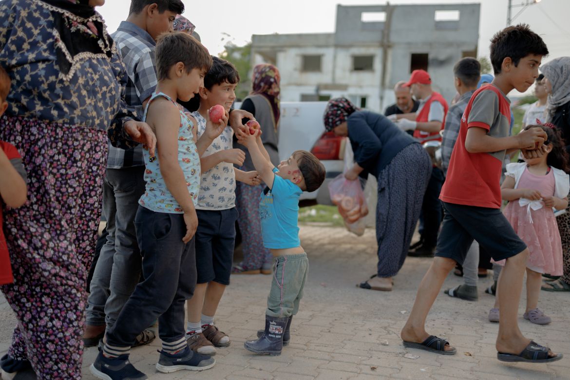 Children queue at a food distribution point in Nurdağı