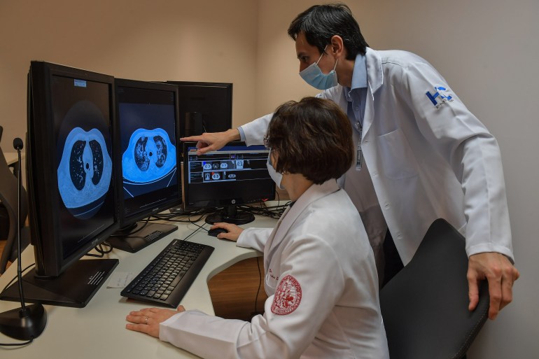 Claudia da Costa Leite (L), professor of the Department of Radiology and Oncology, and the vice-director of the Radiology Institute of the Clinics Hospital, of the Faculty of Medicine of the University of Sao Paulo (InRad), Marcio Sawamura, work, in Sao Paulo, Brazil, on July 29, 2020, amid the new coronavirus pandemic. - A platform called RadVid-19 that identifies lung injuries through artificial intelligence is helping Brazilian doctors detect and diagnose the new coronavirus, which already infected 2,6 million people across the world and killed 91,000 in the country. (Photo by NELSON ALMEIDA / AFP)
