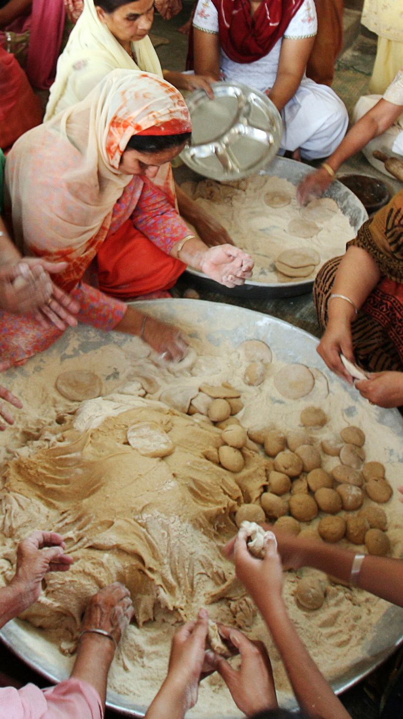 Devotees make chapattis (bread) at a community kitchen in a Gurdwara (Sikh temple) on Baisakhi festival in the northern India city of Chandigarh