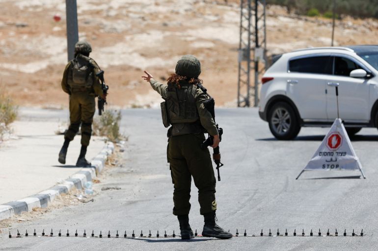 Israeli army soldiers block a road, after a shooting attack, at Tekoa Junction near Bethlehem, in the Israeli-occupied West Bank, July 16, 2023.