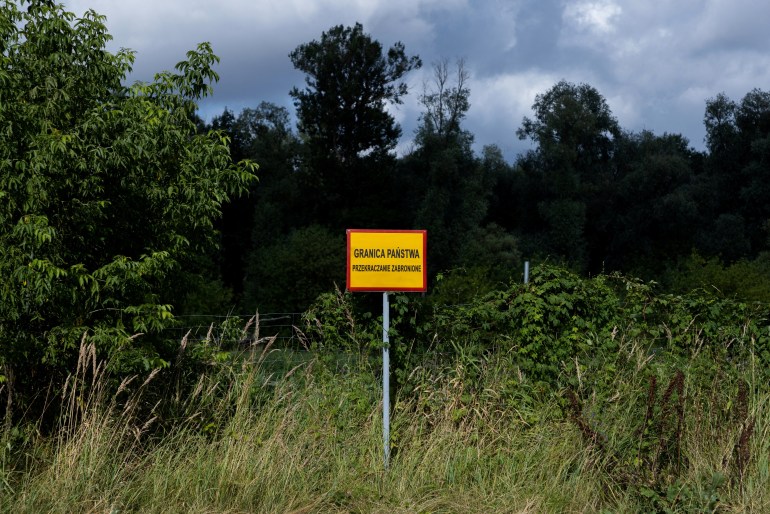 A sign is seen near the Bug River at the Poland-Belarus border, near Kostomloty, Poland July 20, 2023. The sign reads: "State border. Crossing prohibited". REUTERS/Kuba Stezycki