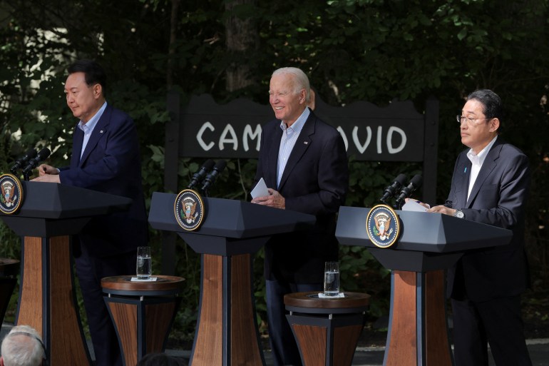 The leaders of Japan, the United States and South Korea stand at podiums during a joint news conference at Camp David