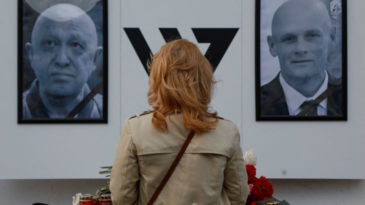 A woman stays in front of a makeshift memorial for Yevgeny Prigozhin, head of the Wagner mercenary group, and Dmitry Utkin, group commander, in Nizhny Novgorod, Russia