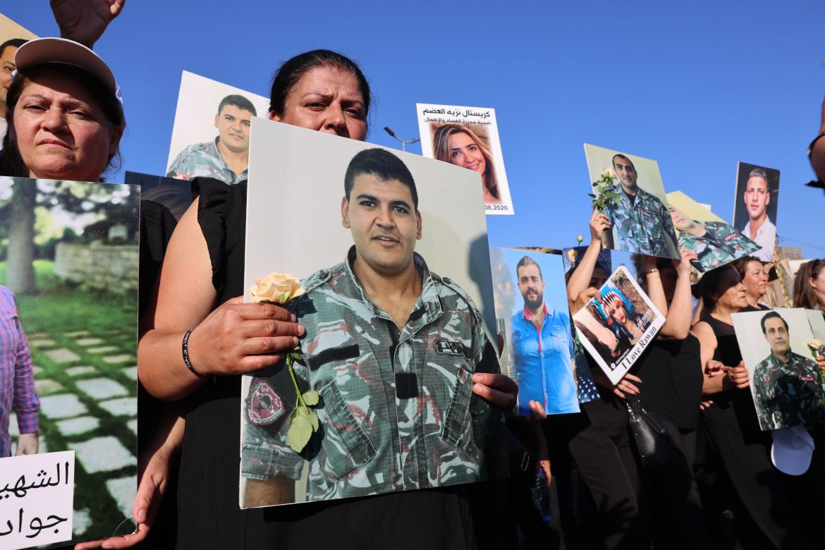 Relatives react as they lift placards depicting the victims of the 2020 Beirut port blast