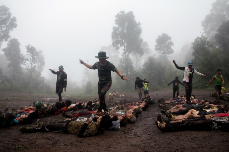 This photo taken on October 16, 2021 shows members of the Karenni Nationalities Defence Force (KNDF) taking part in training at their base camp in the forest near Demoso, in Myanmar's eastern Kayah state. - Young anti-coup recruits line up at a secret camp in Myanmar, hands behind their heads and stomachs braced, waiting for a drill instructor to deliver a punch to toughen them up for their fight against the military. (Photo by STR / AFP) / TO GO WITH MYANMAR-MILITARY-POLITICS-COUP-CONFLICT, FOCUS - TO GO WITH Myanmar-military-politics-coup-conflict, FOCUS