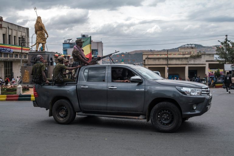 Members of the Amhara militia ride in the back of a pick up truck in the city of Gondar