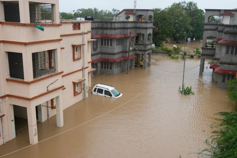 A car is seen partially submerged in the compound of residential quarters of civil hospital employees following heavy winds and incessant rains after landfall of cyclone Biparjoy at Mandvi in Kutch district of Western Indian state of Gujarat