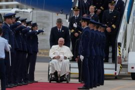 Pope Francis is welcomed by the honor guard as he arrives at the Figo Maduro airbase in Lisbon
