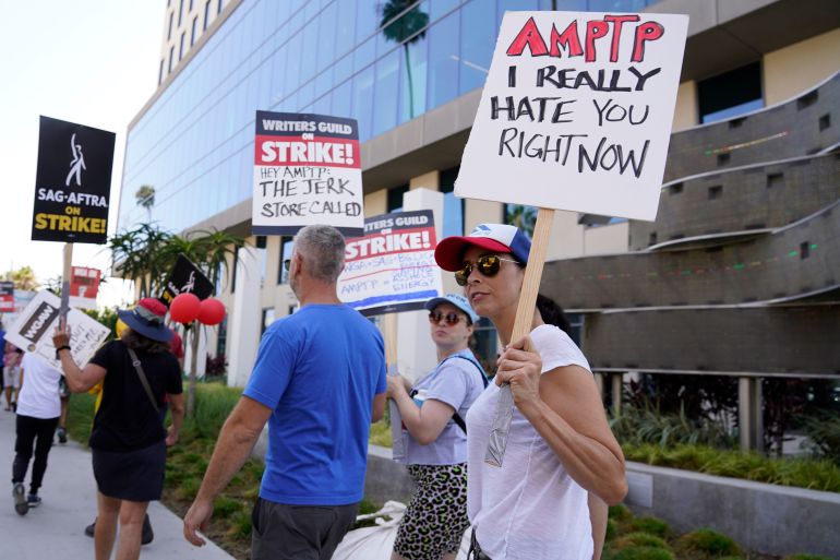 Sarah Silverman, right, walks on a picket line outside Netflix studios on Monday, Aug. 14, 2023, in Los Angeles. The Hollywood writers strike passed the 100-day mark as the film and television industries remain paralyzed by dual actors and screenwriters strikes. (AP Photo/Chris Pizzello)