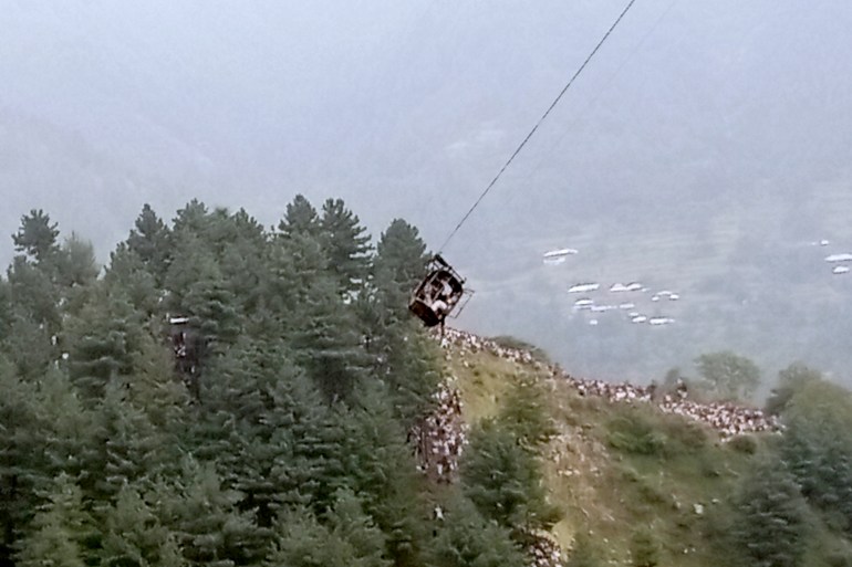 A cable car carrying eight people dangles hundreds of meters above the ground, in Pashto village, a mountainous area of Battagram district in Pakistan's Khyber Pakhtunkhwa province, Tuesday, Aug. 22, 2023. Army commandos using helicopters and a makeshift chairlift rescued eight people from the broken cable car as it dangled hundreds of meters (feet) above a canyon Tuesday in a remote part of Pakistan, authorities said. (AP Photo)