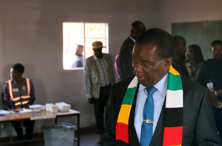 Zimbabwean President Emmerson Mnangagwa casts his vote in the election, He has a scarf in party colours draped around his shoulders