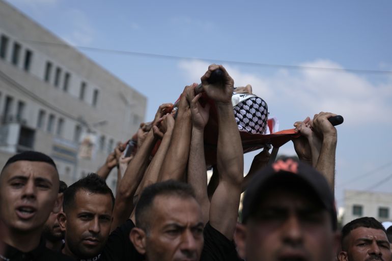 Palestinian mourners carry the body of Ezzedin Kanan, 20, who succumbed to his wounds sustained during an Israeli army operation last month, during his funeral in the West Bank city of Jenin, Saturday, Aug. 26, 2023. The July 3 raid was the most intense Israeli military operation in years in the West Bank, involving airstrikes and hundreds of ground troops, that left a wide swath of damage in its wake. Kanan's death brings the death toll in the raid to 13. (AP Photo/Nasser Nasser)