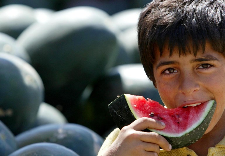 A Palestinian boy eats some watermelon