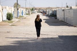 Fawiya walks down a road in the refugee camp