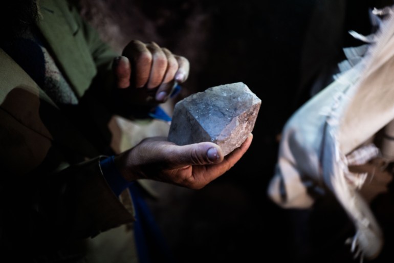 A miner in the pech valley shows a lump of quartz, which he says may indicate nearby stones of higher value