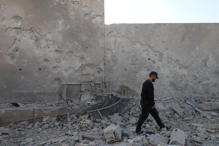 A man walks past rubble caused by Russian raids west of Idlib city in northwest Syria 