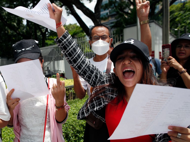 Myanmar protesters In Thailand. They are shouting and punching the air with their arms. They are holding copies of a letter submitted to the US urging it to pressure the Myanmar military to release political prisoners