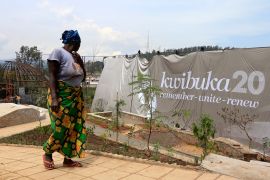 A labourer walks past a banner that reads "Remembering 20 years" at the Kigali Genocide Memorial grounds as the country prepares to commemorate the 20th anniversary of the 1994 Rwandan Genocide in the capital Kigali in April 2014