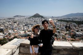 Tourists take a selfie as they visit the Acropolis hill in Athens, Greece