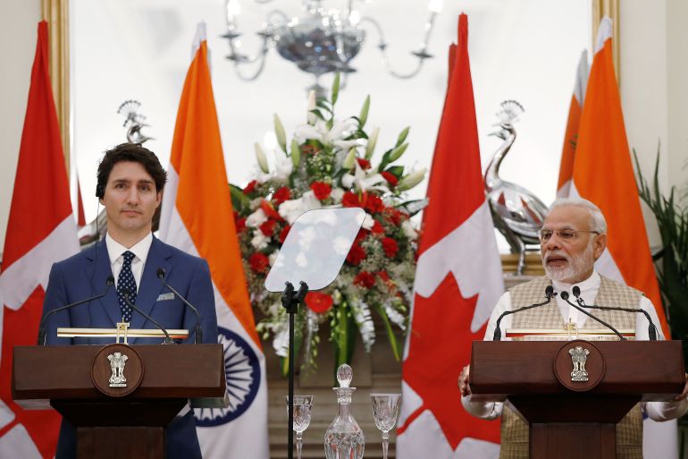 Indian Prime Minister Narendra Modi (R) reads a joint statement as his Canadian counterpart Justin Trudeau looks on at Hyderabad House in New Delhi