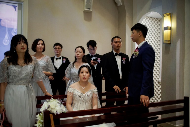 Wei Jiawen, 29, sits on a bench as her husband Pan Wenjun, 30, stands next to her during their wedding, which had to be postponed due to the coronavirus disease (COVID-19) outbreak, in Shanghai, China, August 16, 2020. Wei Jiawen and her husband Pan Wenjun celebrated their nuptials with their family and friends in mid-August in a ceremony that was downsized from their originally planned celebration in February. "We were under pressure both physically and mentally for half a year because of the delayed wedding," said Wei, who gave birth to a daughter while waiting to reschedule the wedding. REUTERS/Aly Song SEARCH "WEDDINGS SONG CHINA" FOR THIS STORY. SEARCH "WIDER IMAGE" FOR ALL STORIES