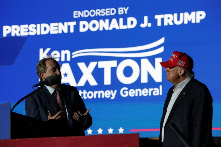 Former U.S. President Donald Trump listens as Texas Attorney General Ken Paxton speaks during a rally in Robstown, Texas, U.S., October 22, 2022. 