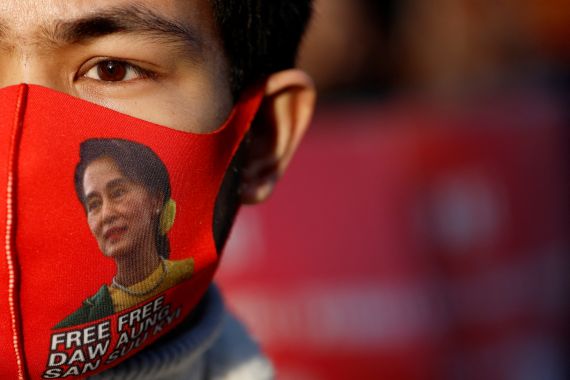 A close up of a Myanmar protester in Jalan. He is wearing a red mask with Aung San Suu Kyi's picture on it