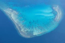An aerial view of Iroquois Reef. The sea inside is turquoise and around the reefs a deeper blue