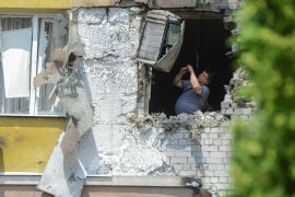 A man is seen inside a damaged multi-storey apartment block following a reported Ukrainian drone attack in Voronezh, Russia, in June 2023 [File: Vladimir Lavrov/Reuters]
