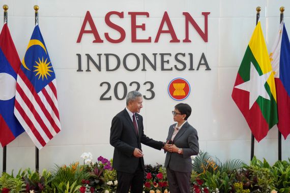 Indonesian Foreign Minister Retno Marsudi greets Singapore foreign minister Vivian Balakrishnan. They are on a stage with a backdrop reading ASEAN Indonesia 2023. There are flags from the member countries of ASEAN