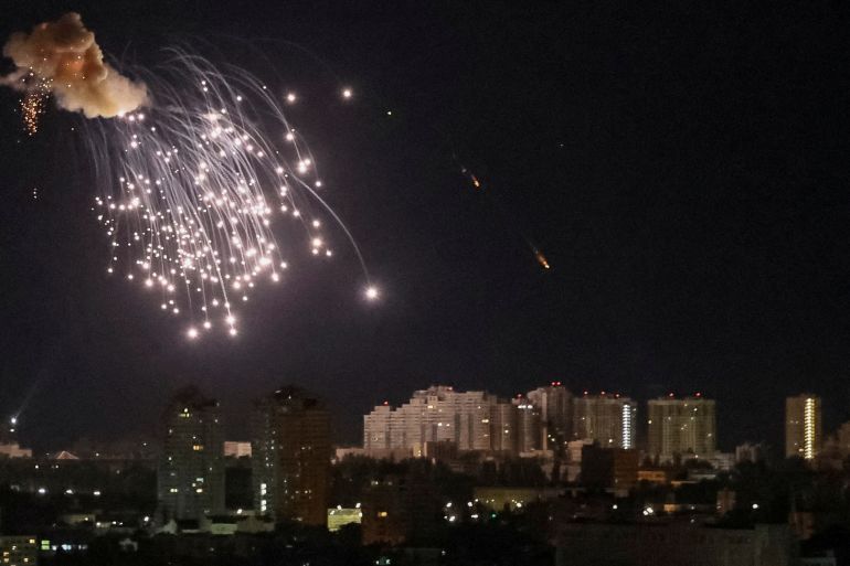 An explosion of a drone is seen in the sky over the city during a Russian drone strike in Kyiv.