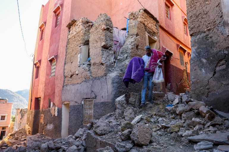 Hussein Adnaie carries belongings out of his damaged house, in the aftermath of a deadly earthquake in Moulay Brahim, Morocco, September 10, 2023. REUTERS/Hannah McKay