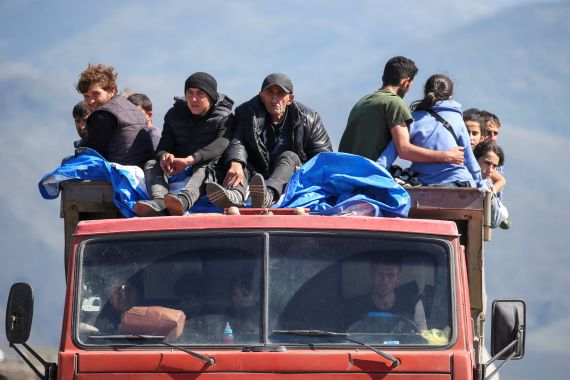 Refugees from Nagorno-Karabakh region ride in a truck upon their arrival at the border village of Kornidzor, Armenia, September 27, 2023