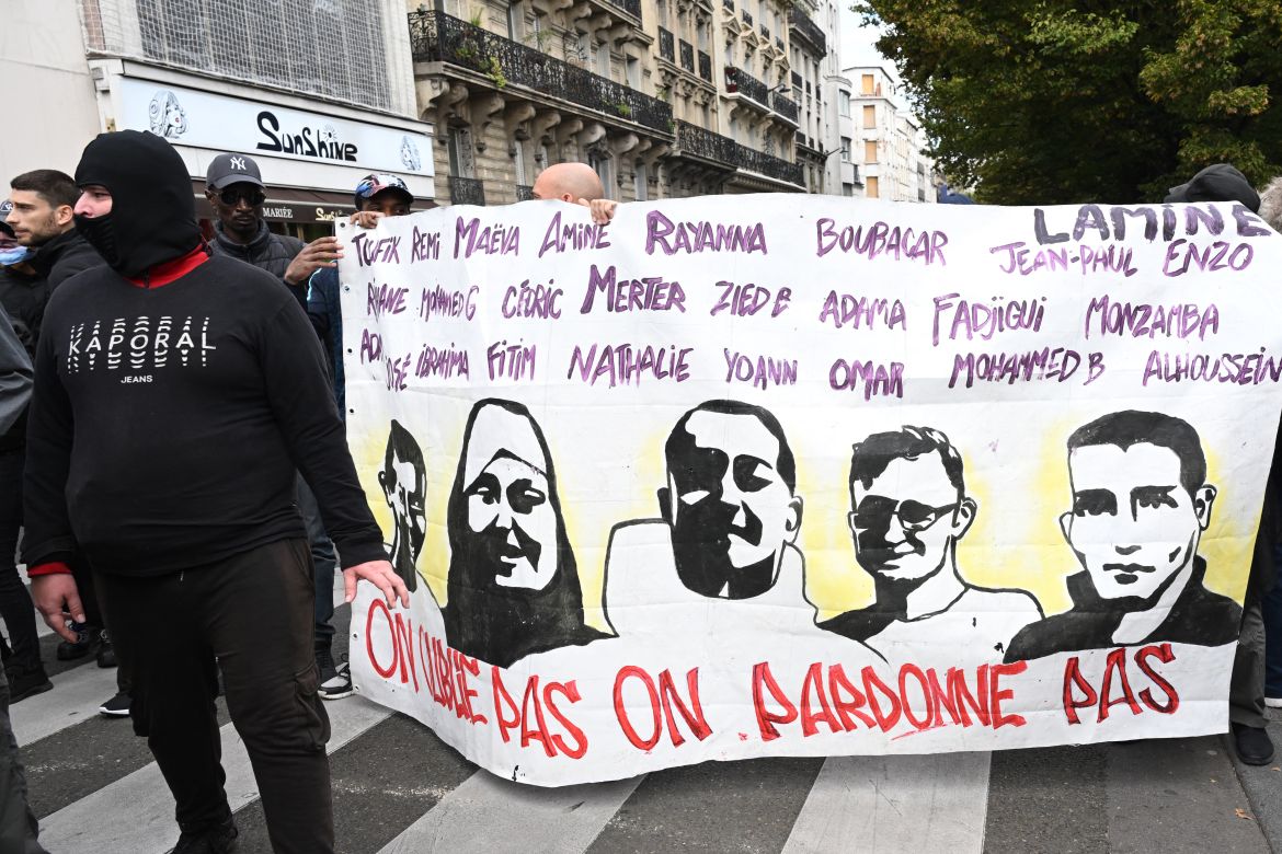 Protestors hold a banner bearing portraits of victims of alleged French police violence with a slogan which reads "We don't forget, we don't forgive" during a "united march" against police brutality called by NGOs, unions and parties, in Paris