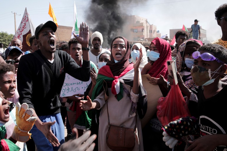 People chant slogans during a protest to denounce the October military coup, in Khartoum, Sudan, Saturday, Dec. 25, 2021. Sudanese security forces fired tear gas to disperse protesters as thousands rallied since earlier in the day, even as authorities tightened security across Khartoum, deploying troops and closing all bridges over the Nile River linking the capital with its twin city of Omdurman and the district of Bahri, the state-run SUNA news agency reported.(AP Photo/Marwan Ali)